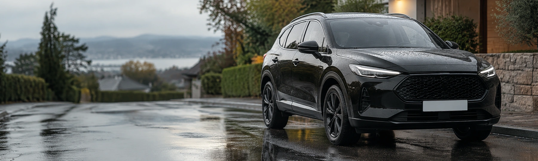 A black crossover on a wet suburban street after rain